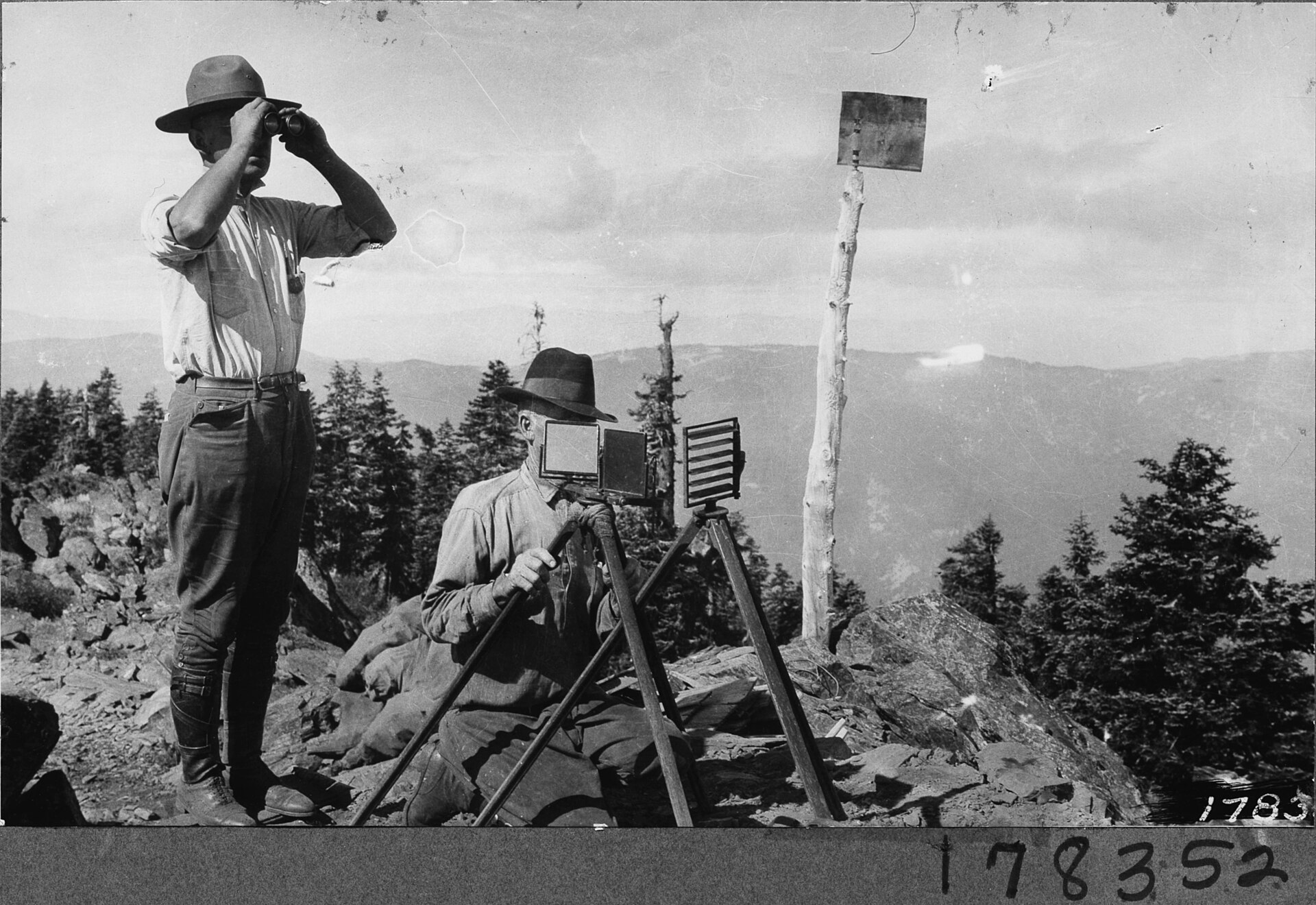 United States Forest Service photograph 178352, taken August 20, 1923 by L.A. Barrett for the USFS. Forest officers heliographing from Bl…