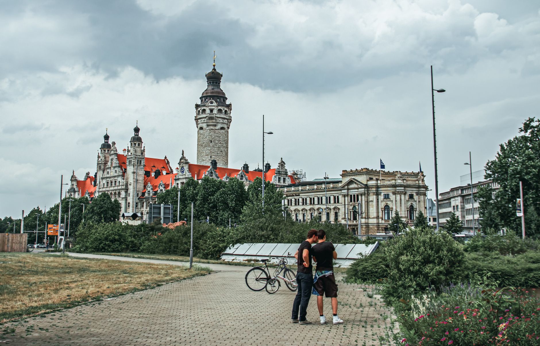 Scenic view of historical architecture with bicycles and people in Leipzig, Germany on an overcast day.